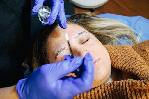 Client receiving a relaxing brow lamination service, where eyebrow hairs are professionally lifted and shaped for a sleek and well-groomed appearance. Professional brow care and maintenance.