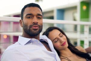 Couple relaxing on a bench, showing off the clean results of waxing nose hair.